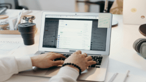 osoba pracująca na laptopie w biurze, optymalizująca skrzynkę odbiorczą outlook